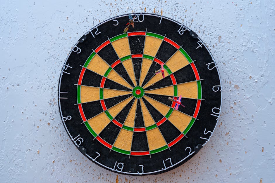 Vibrant dartboard against textured wall with darts on bullseye, symbolizing precision.