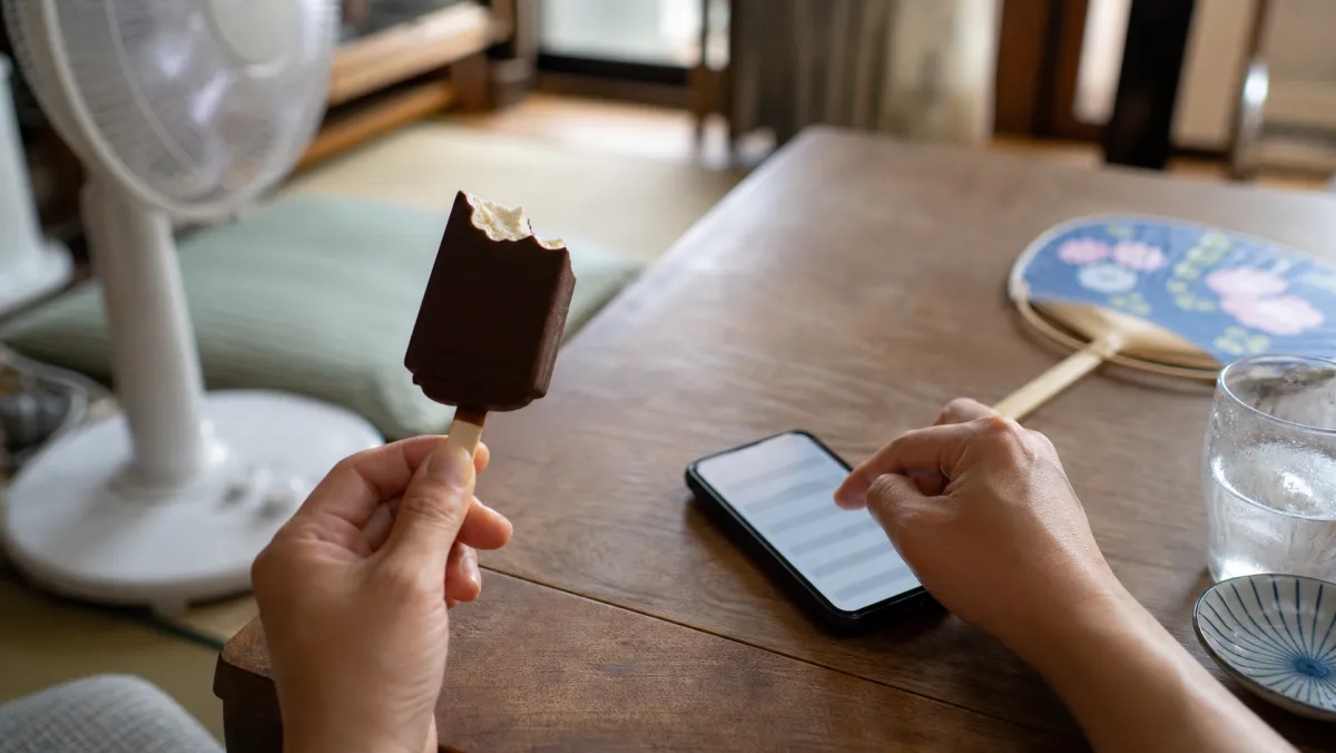 ローテーブルでスマホにメモしながらアイスを食べる手元