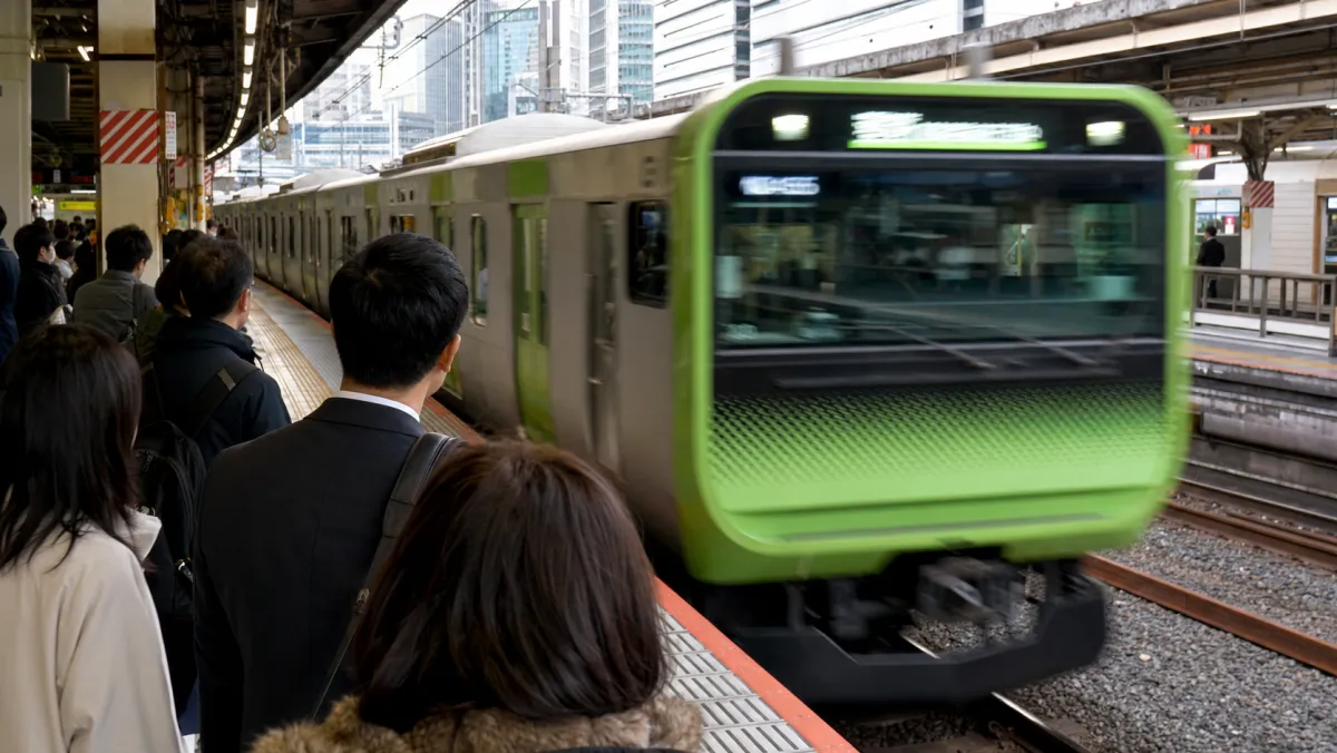 山手線ホームに緑帯の電車が入線する場面